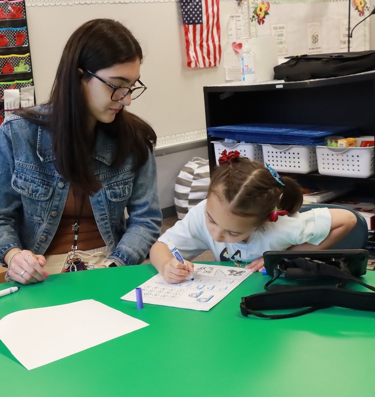 Female student working with a child in class.