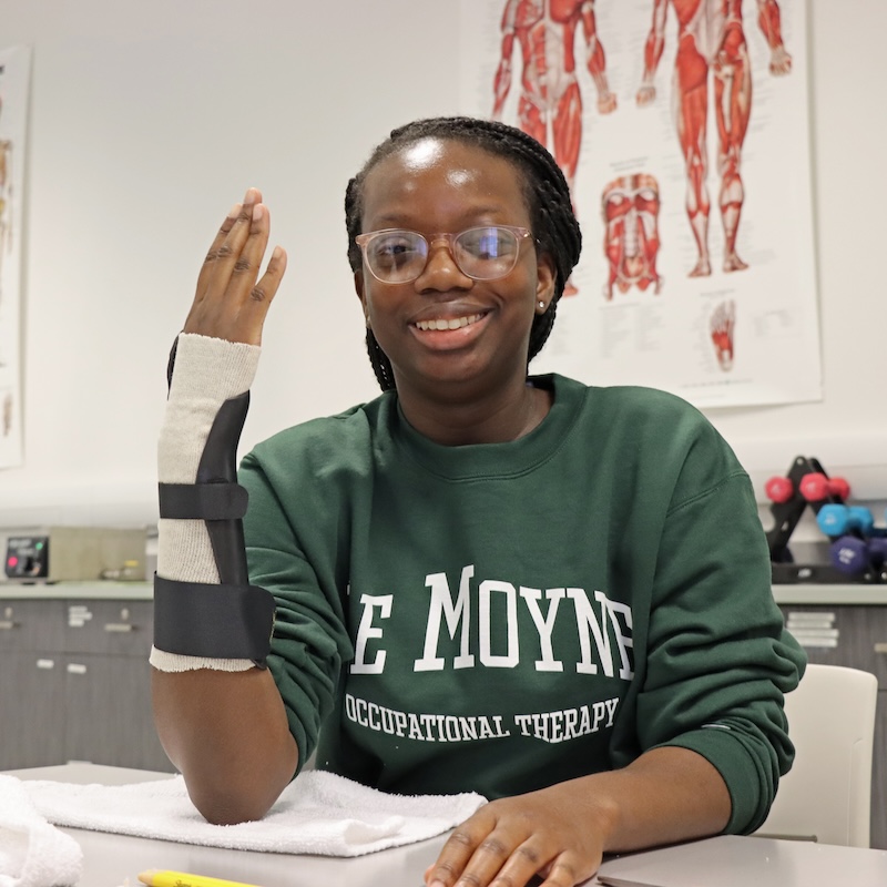 A student showcasing a splinted wrist during a lab.