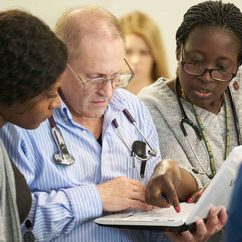 Two instructors talking with a student.