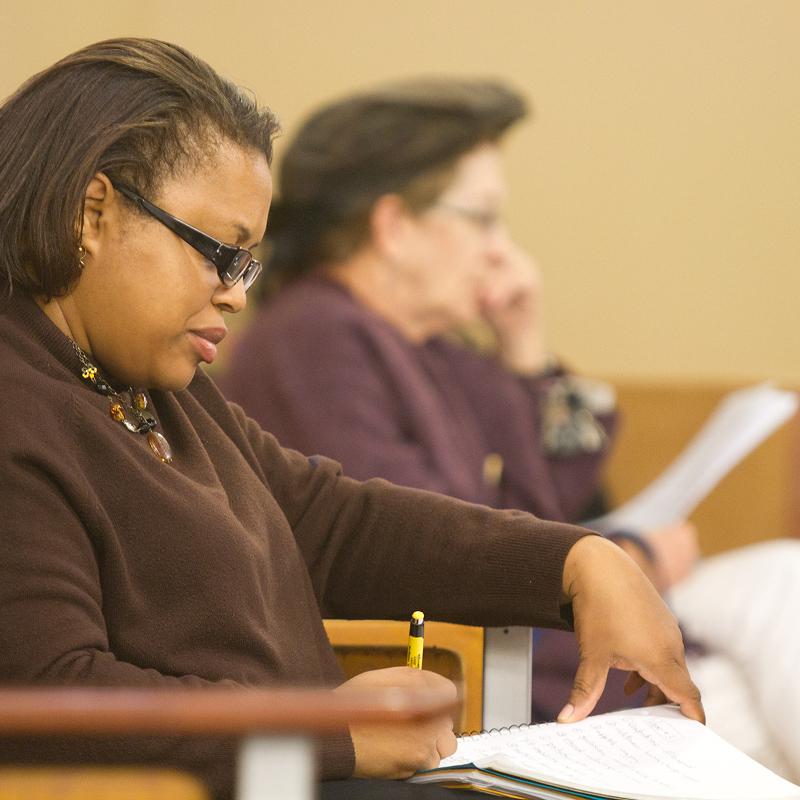 A woman taking notes in class.