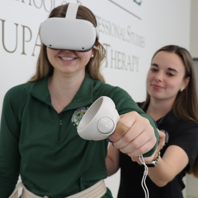 Two students practicing with a virtual reality device.