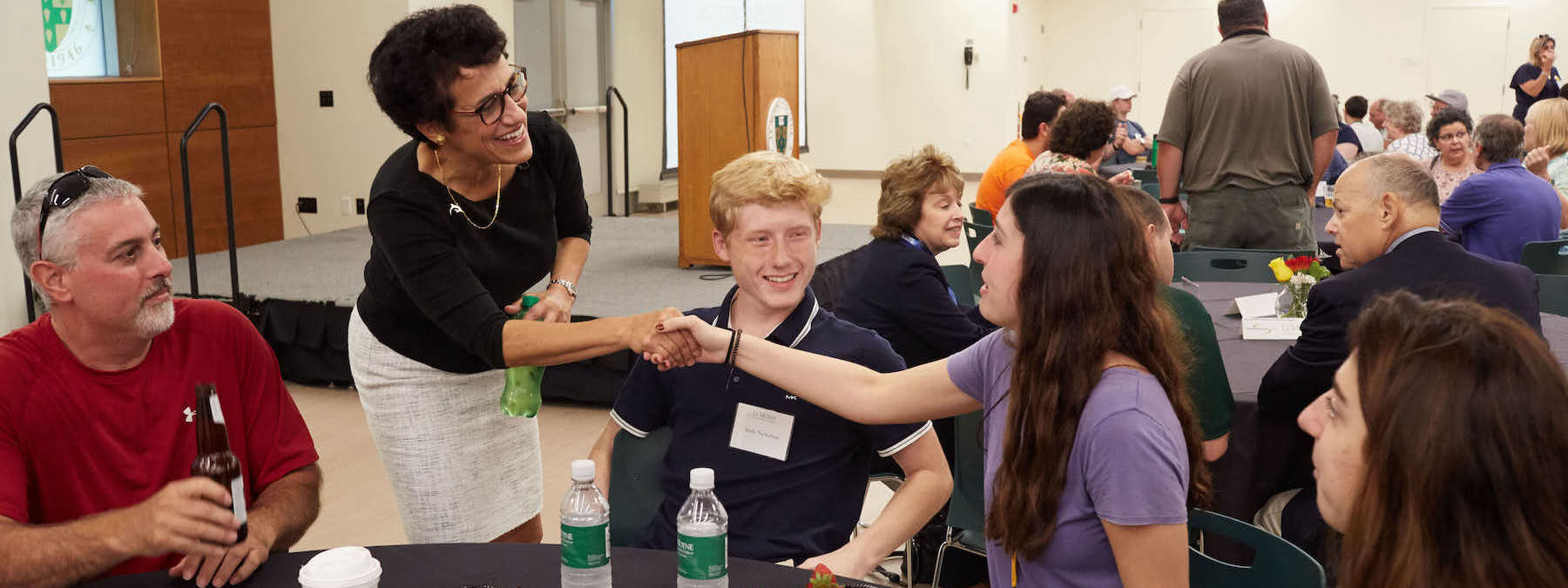 Linda greets students at an accepted student event.