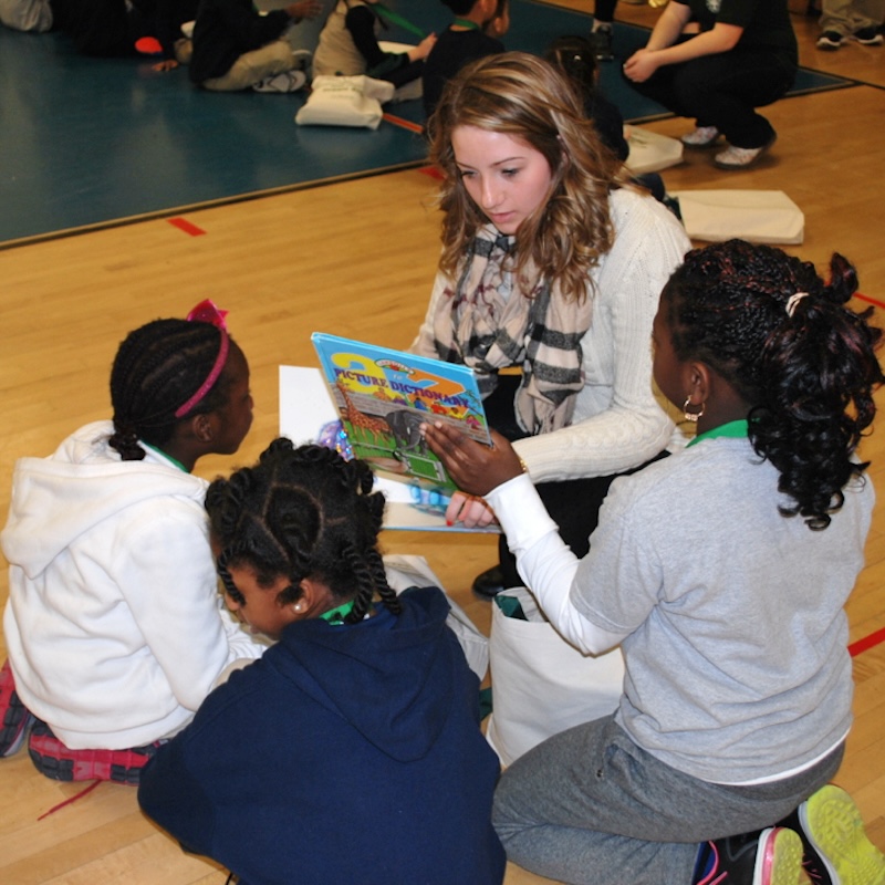 Female student teaching 3 children